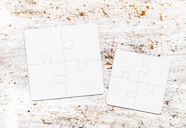 Разного размера куски белой головоломки на столе — стоковое фото