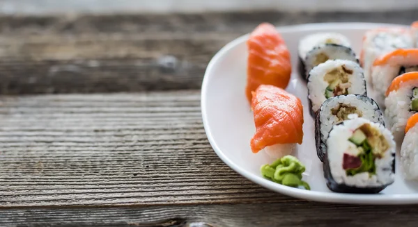 Verschiedene Sushi auf weißem Teller — Stockfoto