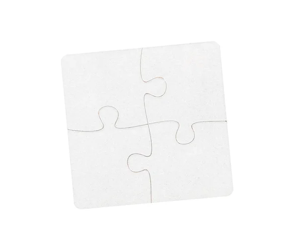 Quatro peças de quebra-cabeça branco conectado na mesa — Fotografia de Stock