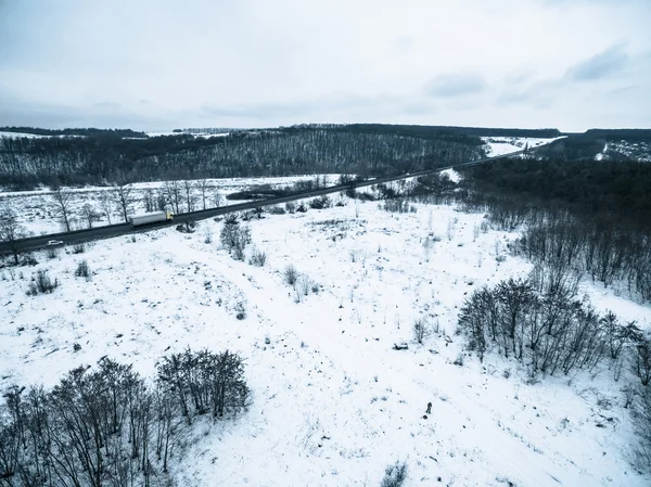 Luchtfoto op een besneeuwde veld en weg van quadrocopter — Stockfoto