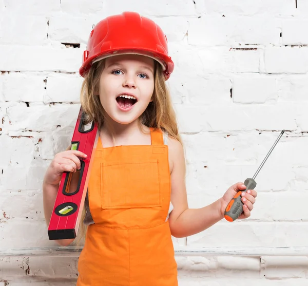 Симпатичная девушка-работница со строительным уровнем и отверткой — стоковое фото