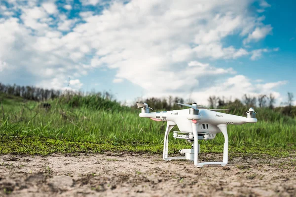 White quadrocopter standing on the ground — Stock Photo, Image