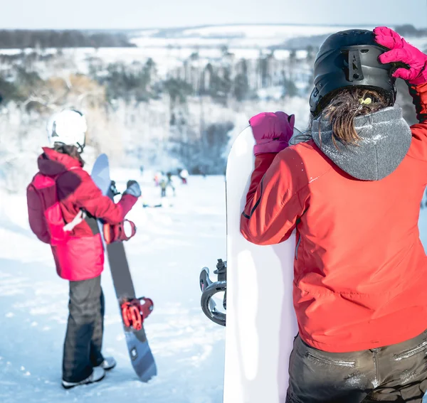 Gente en traje de esquí sosteniendo tablas de snowboard en un snowhill —  Fotos de Stock