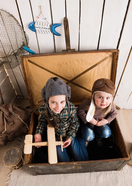 Twee grappige kleine meisjes in grote houten kist — Stockfoto