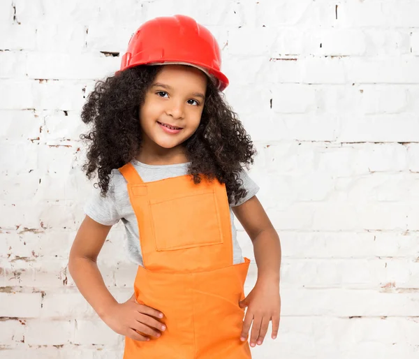 Маленькая девочка в форме ремонтника апельсинов — стоковое фото