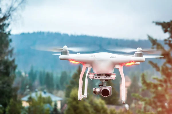White quadrocopter with camera in mountains — Stock Photo, Image