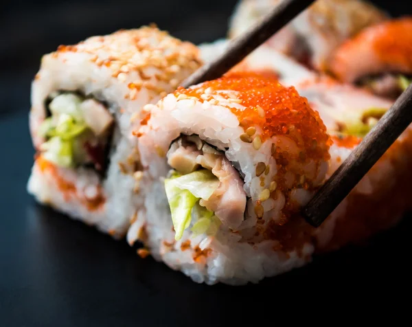 Close-up van sushi rolt met stokjes — Stockfoto