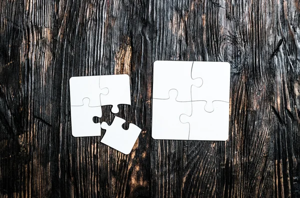 Puzzles blancs sur table en bois sombre — Photo