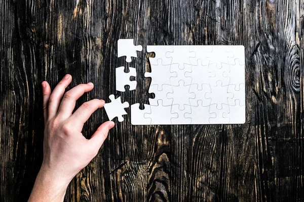 Hand collecting white puzzle — Stock Photo, Image