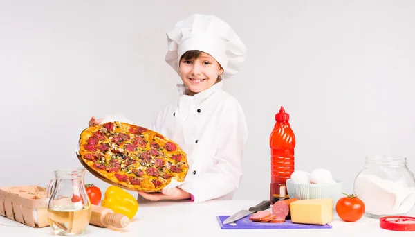 Mały kucharz uśmiechający się dziewczyna z big pizza w ręce — Zdjęcie stockowe