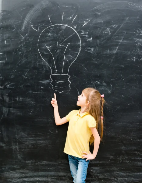Cute little girl pointing on a drawn lamp — Stock Photo, Image