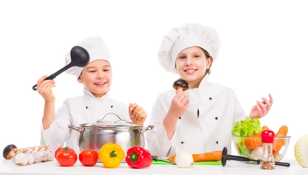 Menino e menina com legumes para sopa na mesa — Fotografia de Stock