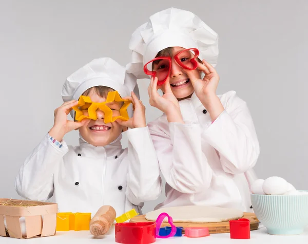 Zwei lustige Kinder spielen in der Küche — Stockfoto