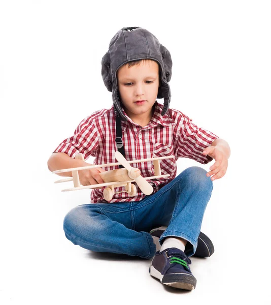 Kleiner Junge mit Pilotenhut und Spielzeugflugzeug — Stockfoto