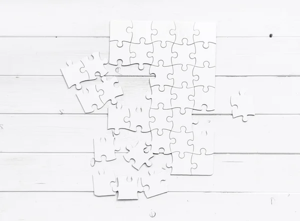 Weißes unfertiges Puzzle auf weißem Tisch — Stockfoto