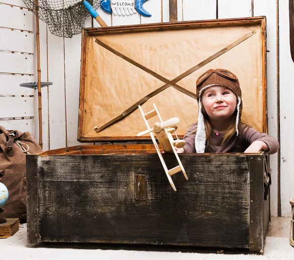 Маленька дівчинка в грудях з дерев'яною площиною в руках — стокове фото