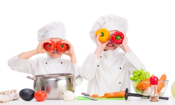 Dvě malé kuchaři hrací zeleninu do polévky Royalty Free Stock Obrázky