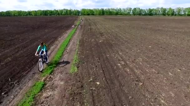 Bycyclist ridning cykeln i ett fält — Stockvideo