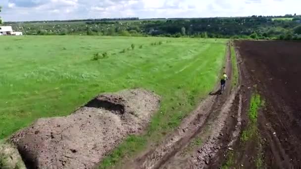 Велосипедист катается на велосипеде в поле — стоковое видео