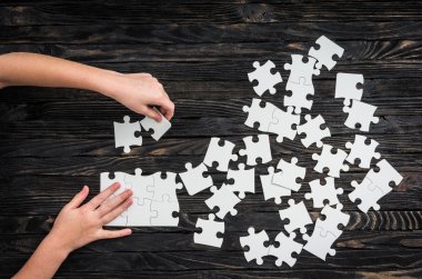 puzzle parçaları toplamaya başlayan eller