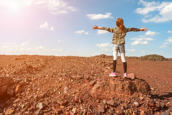 Chica en piedra grande en la zona de hierro mineral de tierra desde la parte posterior —  Fotos de Stock