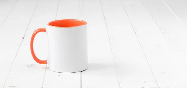 White cup with orange handle and inside — Stock Photo, Image