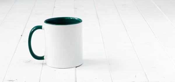 Copo branco com alça verde e para dentro — Fotografia de Stock