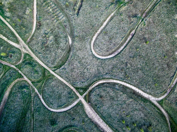 Estradas laminadas à terra em um campo — Fotografia de Stock