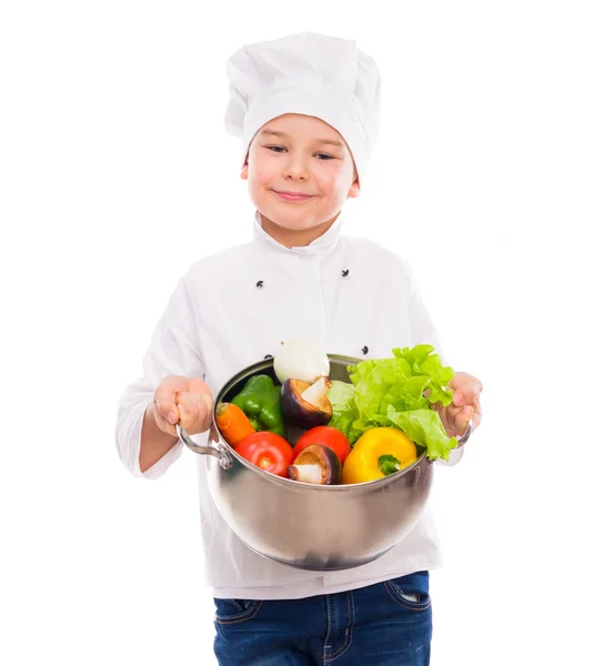 Rolig liten pojke-kock anläggning skål med grönsaker i händer — Stockfoto