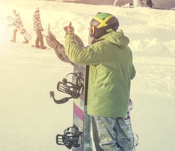 Peolpe in ski suits with snowboards taking photo on a hill — Stock Photo, Image