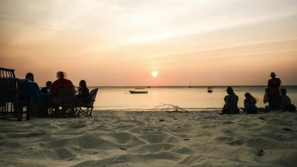 Coucher de soleil sur la plage africaine avec des groupes de personnes au repos, timelapse — Video