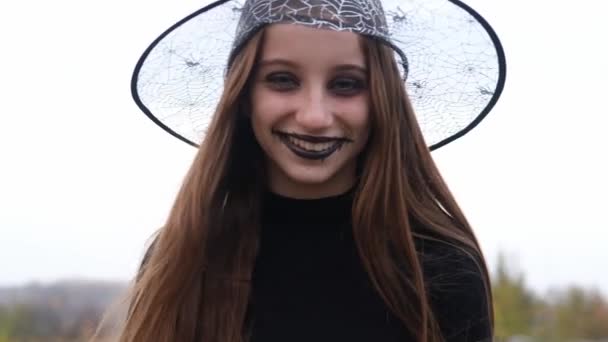 Ung flicka i häxa hatt med ansikte konst — Stockvideo