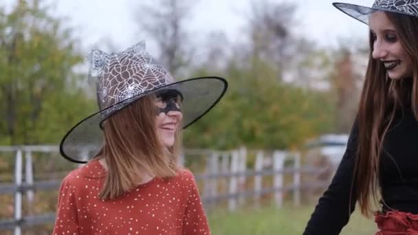Улыбающиеся девушки в шапках ведьм ходят — стоковое видео