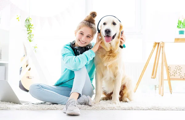 Menina feliz segurando fones de ouvido no cão — Fotografia de Stock