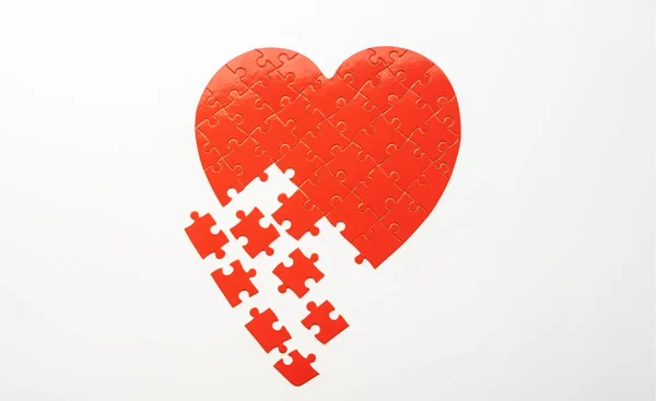 Головоломка в форме сердца с разбросанными кусочками — стоковое фото