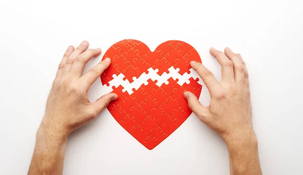 Mani corrispondenti pezzi di puzzle cuore — Foto Stock