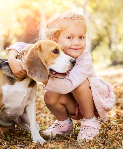 Kleines Mädchen umarmt einen Hund — Stockfoto