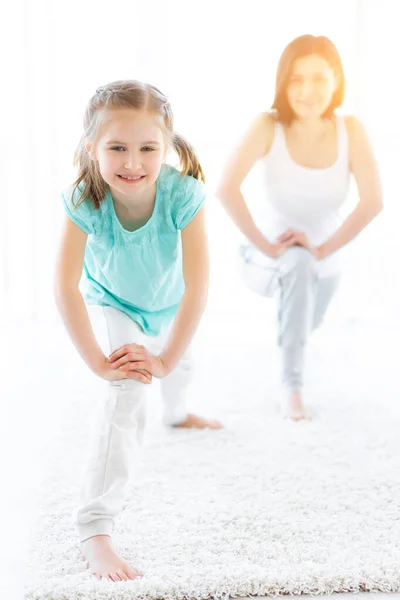 Menina com a mãe fazendo exercícios de ginástica — Fotografia de Stock