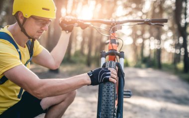 Bisikletteki lastik basıncını kontrol eden adam