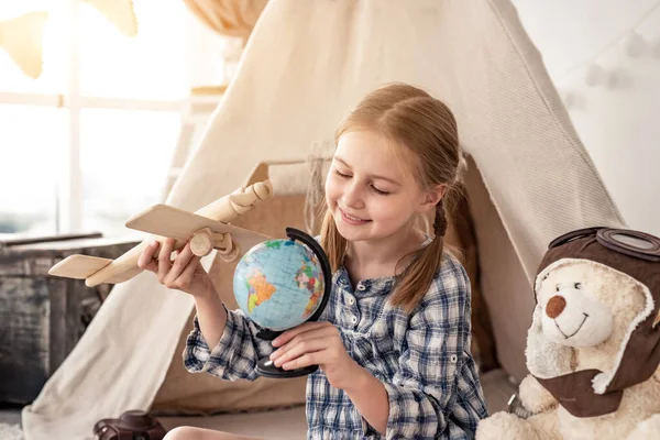 Menina brincando com globo e avião de madeira — Fotografia de Stock