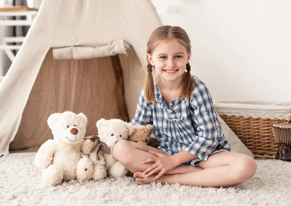 Bambina seduta vicino agli orsacchiotti — Foto Stock