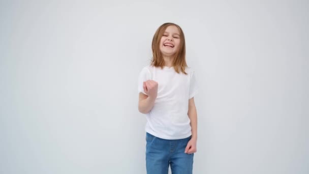 Menina bonito uma camiseta branca é muito feliz — Vídeo de Stock