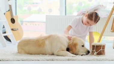 Güzel küçük kız köpekle oynuyor.