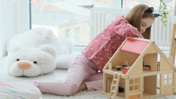 Niña jugando con casa de madera — Vídeos de Stock