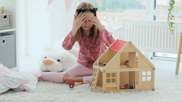 Kleines Mädchen spielt mit Holzhaus — Stockvideo