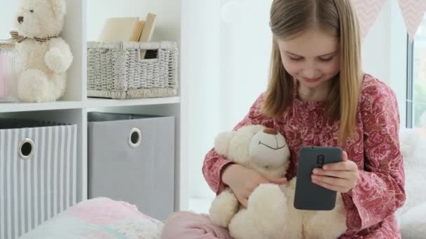 Usmívající se holčička brát selfie pomocí smartphonu — Stock video