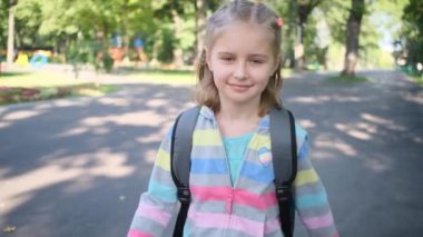 Okul kızı park yolunda yürüyor.