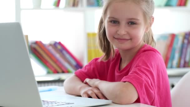 Niña sonriente con portátil en la escuela — Vídeos de Stock