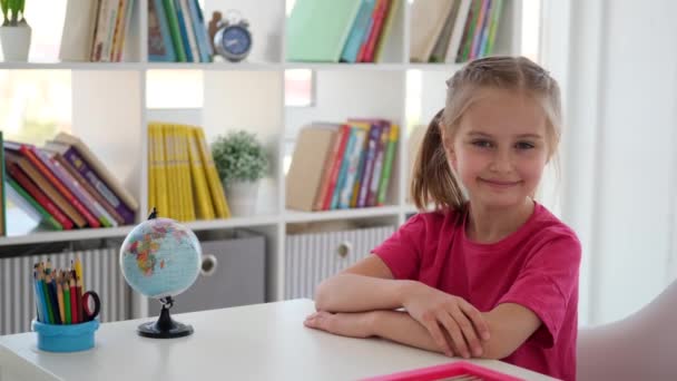 Grundskolans flicka sitter vid skrivbordet — Stockvideo