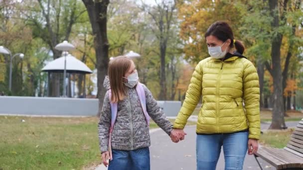 Niña con madre en máscaras caminando — Vídeo de stock